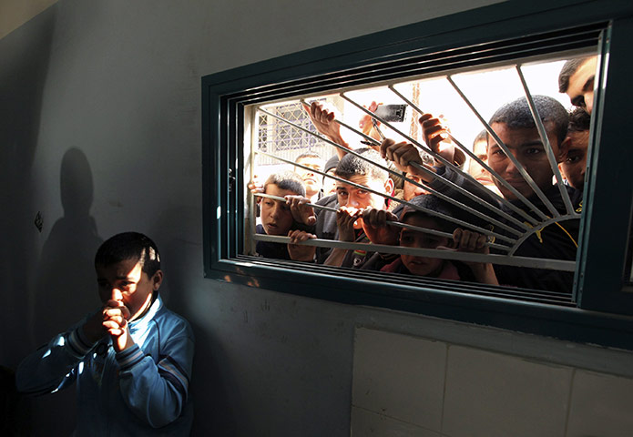 24 hours in pictures: Palestinians look through a hospital window in the northern Gaza Strip
