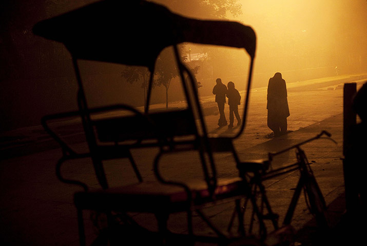 24 hours in pictures: New Delhi, India: A man stands in a blanket on a cold and foggy morning