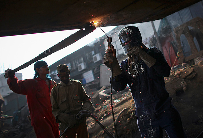 Week in Business: A worker welds a vessel at a ship-repair yard in Mumbai