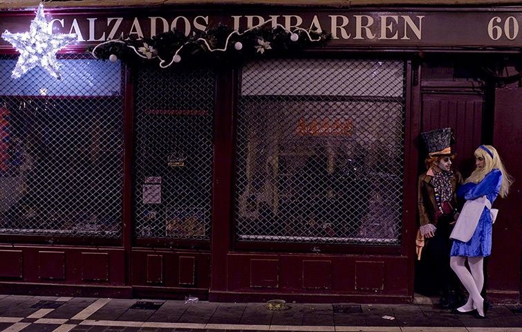 24 hours: Pamplona, Spain:A couple wearing fancy dress stand in a doorway 