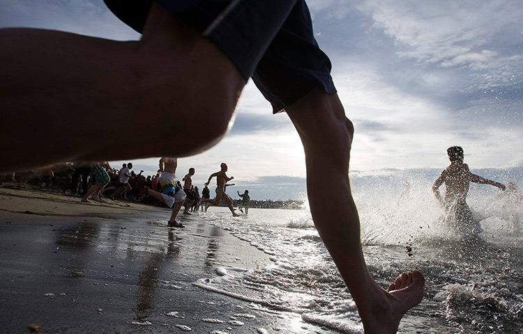 24 hours: Vancouver, Canada: Revellers run into English Bay for a New Year's day swim