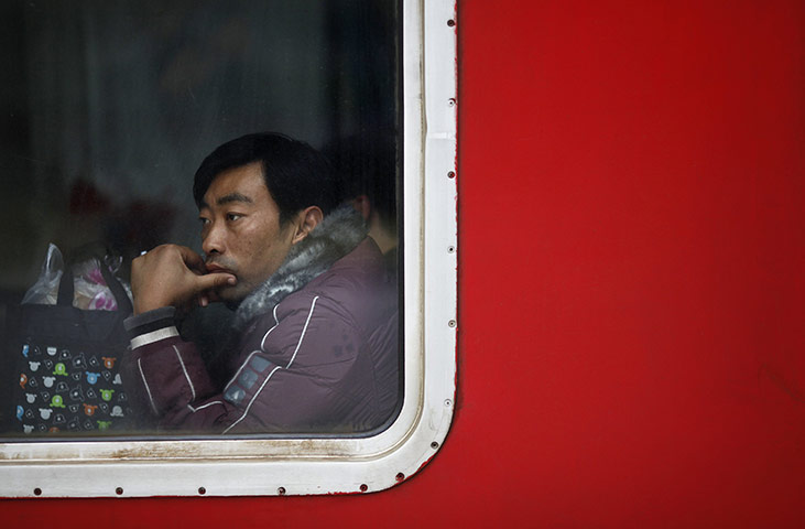 China Spring Festival: A passenger sits inside a train at Shanghai's railway station