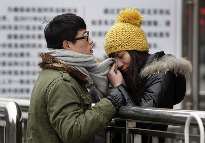 China Spring Festival: A woman wipes her tears with her partner's scarf