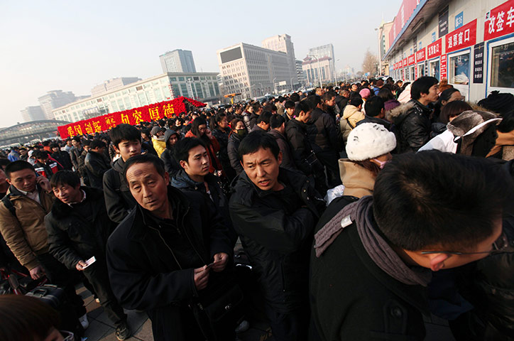 China Spring Festival: Passengers queue to buy train tickets outside a railway station in Beijing