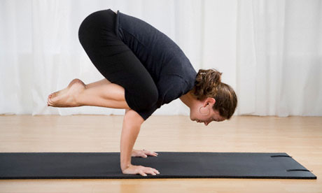 Woman on exercise mat practising yoga