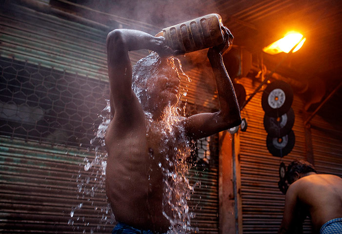 24 Hours: A man bathes in New Delhi