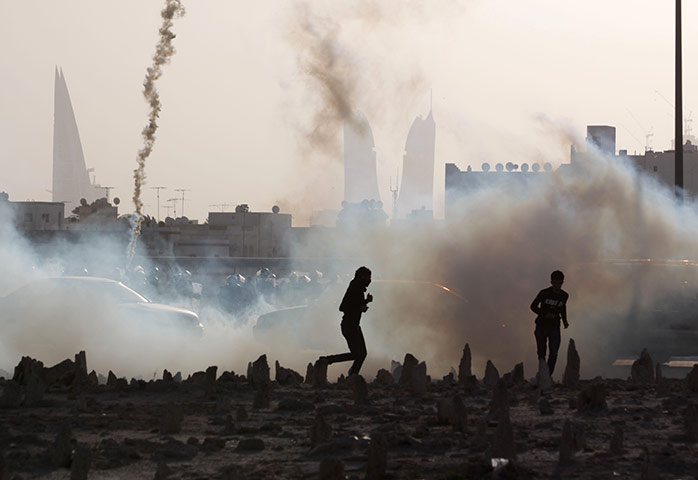 24 hours : Muharraq, Bahrain: Bahraini youths react to tear gas fired by riot police 