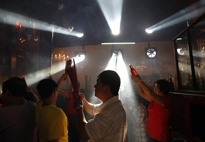 24 hours in pictures: Jakarta, Indonesia: People hold incense sticks as they pray