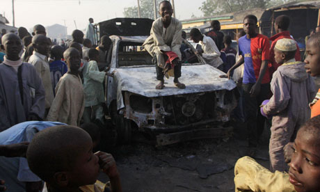 A child stands on a burnt-out police truck outside the attacked police station