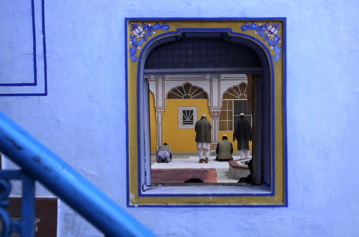 24 hours in pictures: Men offer prayers at the Jaipur Literature Festival