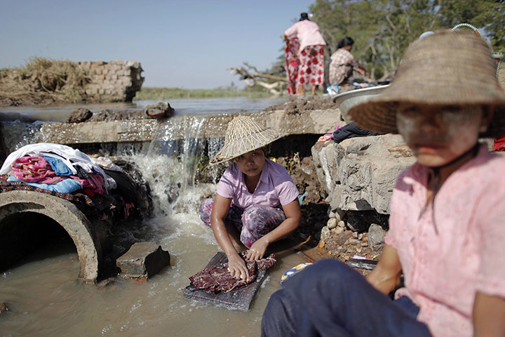 Burma economic reform: Women wash clothes at a river on the outskirts of Naypyitaw, Burma