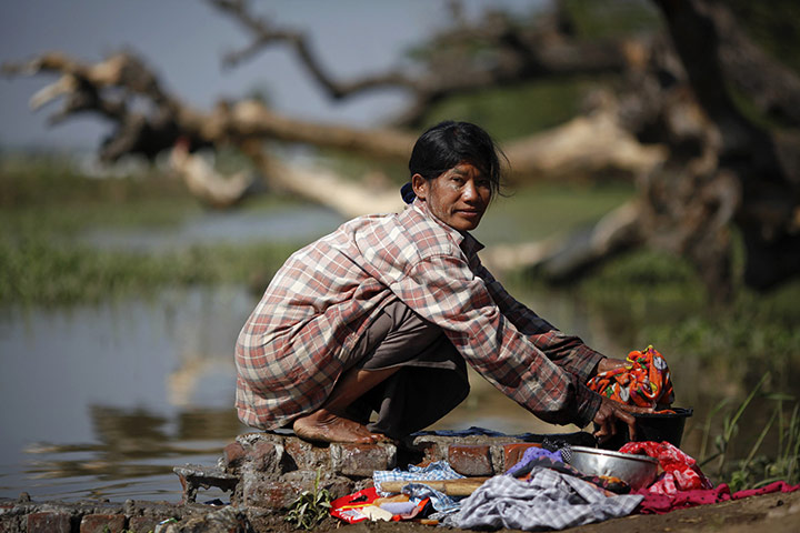 Burma economic reform: A woman washes clothes at a river on the outskirts of Naypyitaw, Burma