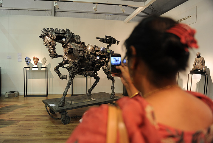 India art fair: A visitor photographs a sculpture by South African artist Willie Bester