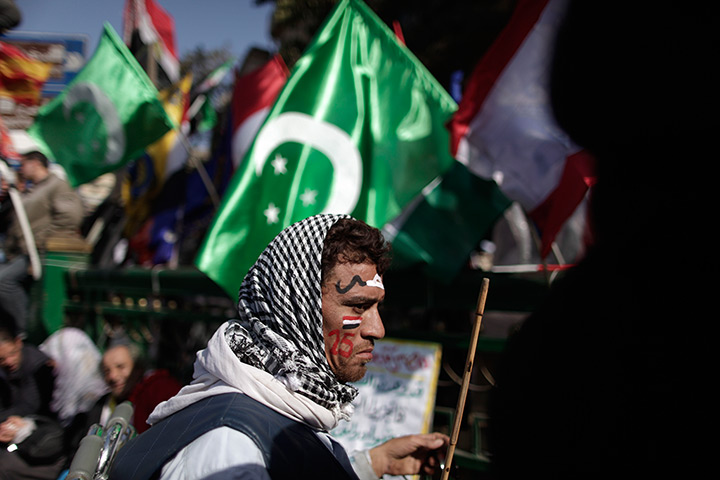 Egypt one year rally: A man carries a flag from the kingdom of Egypt