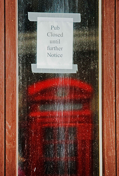 Week in business: A telephone box is reflected in the window of a closed pub in the City