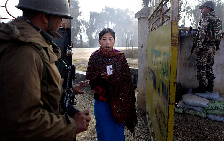 24 Hours: An Indian woman shows her election card as she enters a polling station