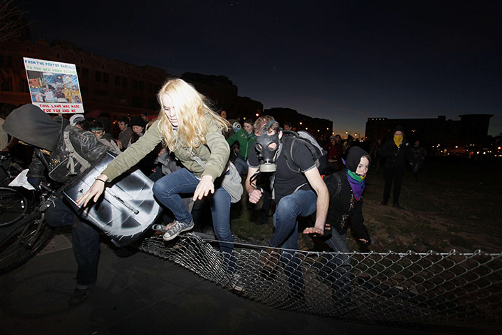 Occupy Oakland: Protestors knock down fences to escape from the police in Oakland