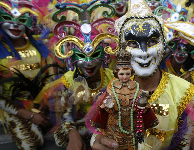 24 hours in pictures: a man holds an image of the infant Jesus in Manila, Philippines