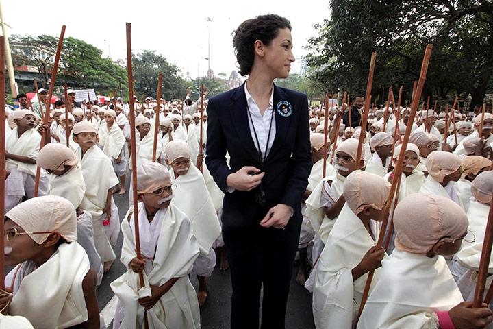 Gandhi world record event: An official of Guinness World Records, poses with boys dressed as Gandhi 