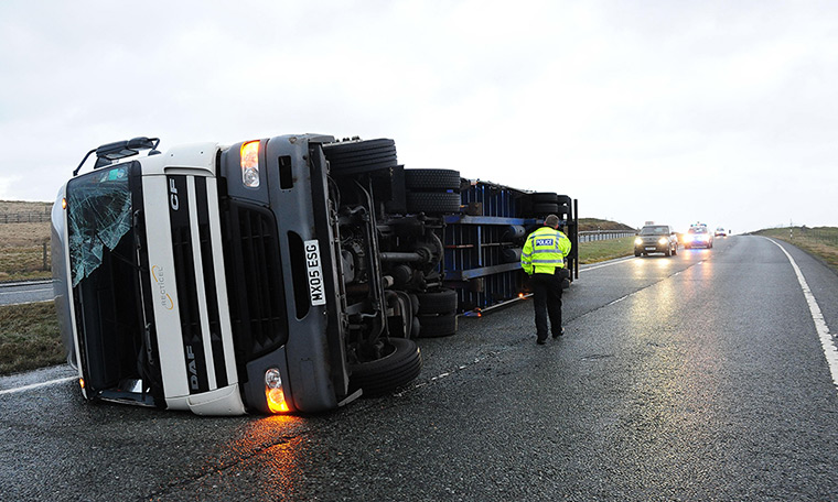 stormy weather in uk: A lorry lies on its side after being blown over in high winds on the A66