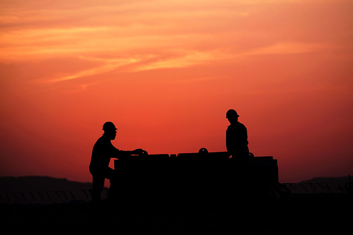 24 hours in pictures: Oil field  workers prepare a new site at sunset , Bahrain