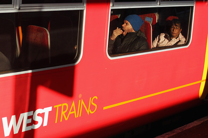 24 hours in pictures:  Passengers sit on a train at Clapham Junction Station, London