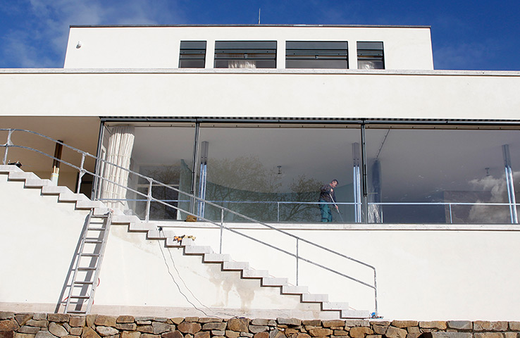 Villa Tugendhat: A worker is seen through one of the large glass windows 