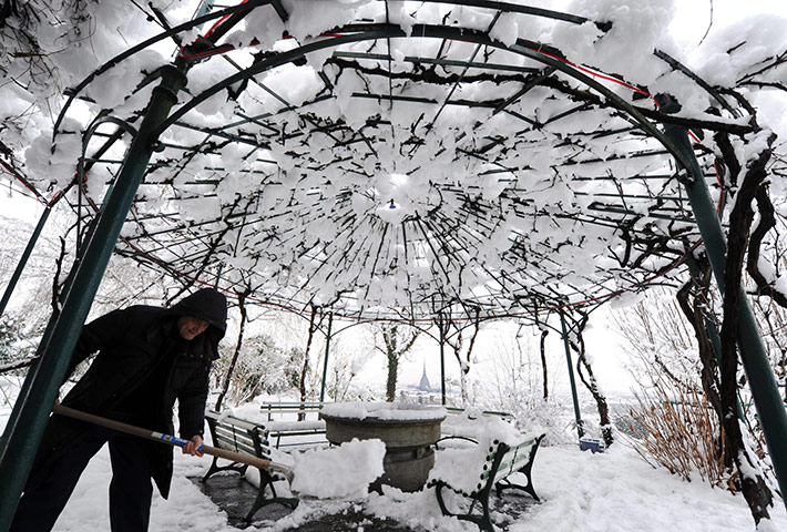World weather: A man removes snow at a park, Turin, Italy