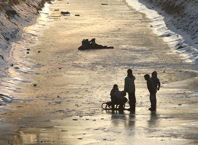 World weather: People skate, sledge and walk on the frozen Hron river Zvolen, Slovakia