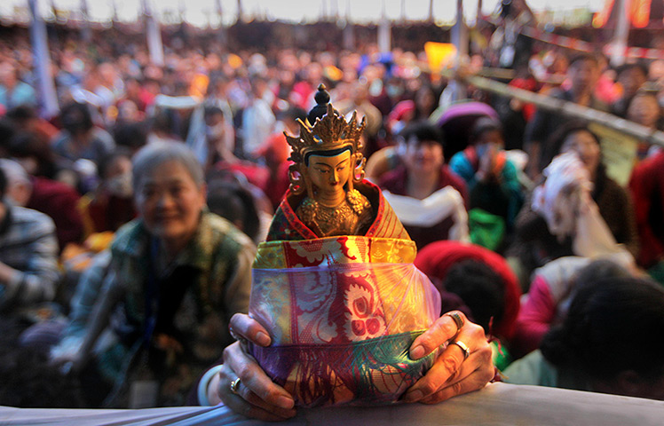 FTA: Altaf Qadri: A Chinese devotee holds an idol as he listens to the Dalai Lama