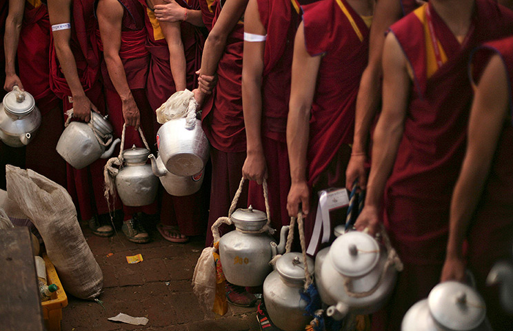 FTA: Altaf Qadri: Buddhist monks hold kettles to be filled with tea 