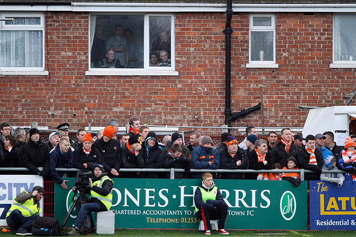 FA Cup Round-up: Fans watch the game from a house next to Highbury Stadium