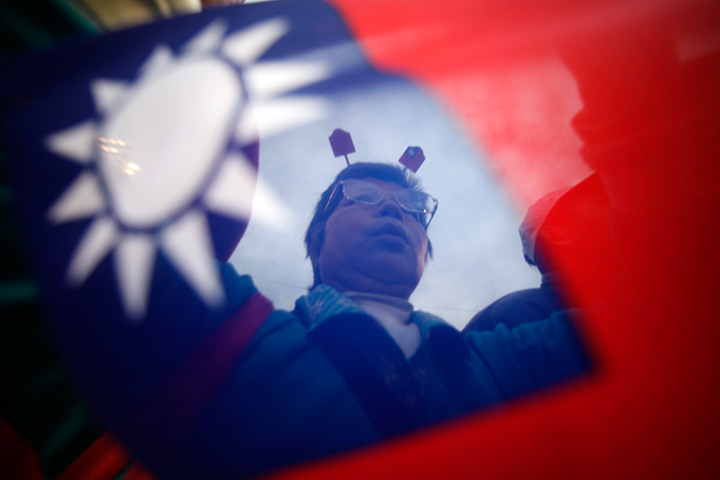 24 hours in pictures: a supporter of taiwanese president  Ma Ying-jeou at a campaign rally