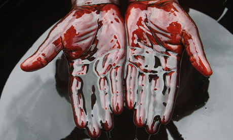 A man covers his hands in crude oil during a Nigerian protest against Shell after last month's spill