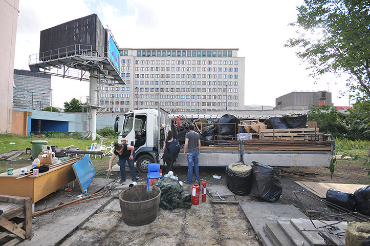 Oasis Childrens' Venture: People load up a lorry with timber at the site of a deconstructed building