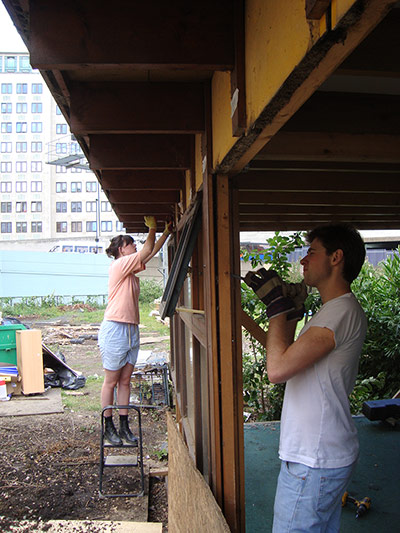 Oasis Childrens' Venture: Workers starting to dismantle a building exposing a wooden frame structure