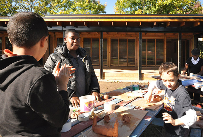 Oasis Childrens' Venture: Children have fun in a pottery session outside a new play centre