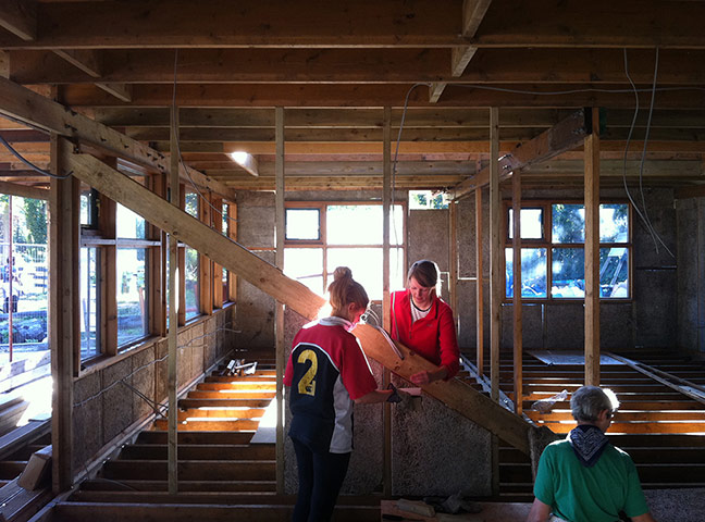 Oasis Childrens' Project: Three people work together inside a new building structure