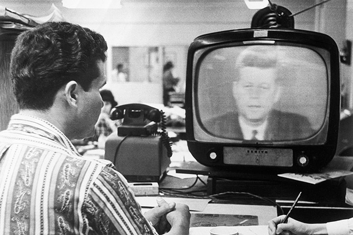 Cuban missile crisis : Cuban man watching President Kennedy speak on TV