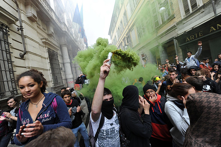 24 horus in pictures: A protester lights up a smoke bomb during the students' demonstration