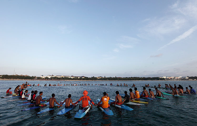 Bali anniversary: Surfers join hands during a 