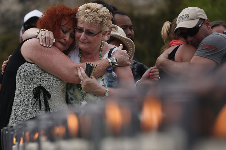 Bali anniversary: Family members embrace after laying flowers at the remembrance pool in Bali