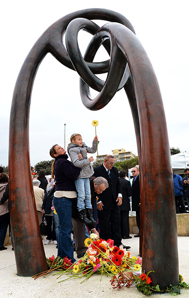 Bali anniversary: People lay flowers after a ceremony at Coogee Beach