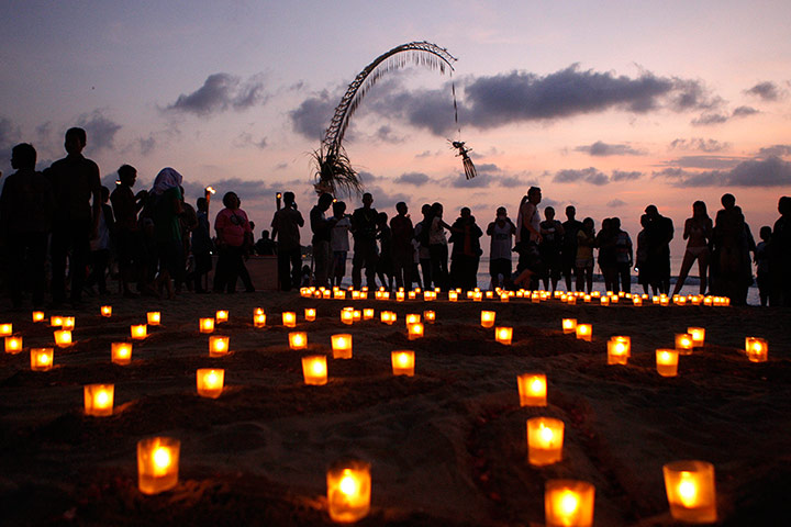 Bali anniversary: Relatives and survivors light candles at the beach during a memorial