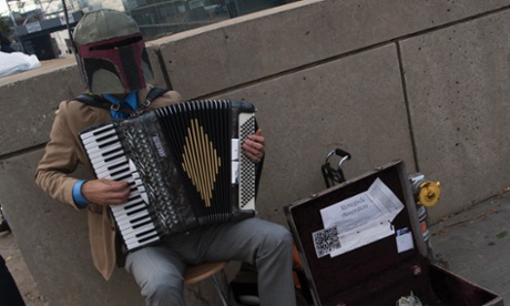 A man dressed as Star Wars character Boba Fett plays the accordion outside Comic Con. 