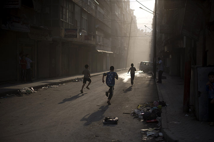 Twenty Photographs: Syrian boys run for cover from mortar in Aleppo