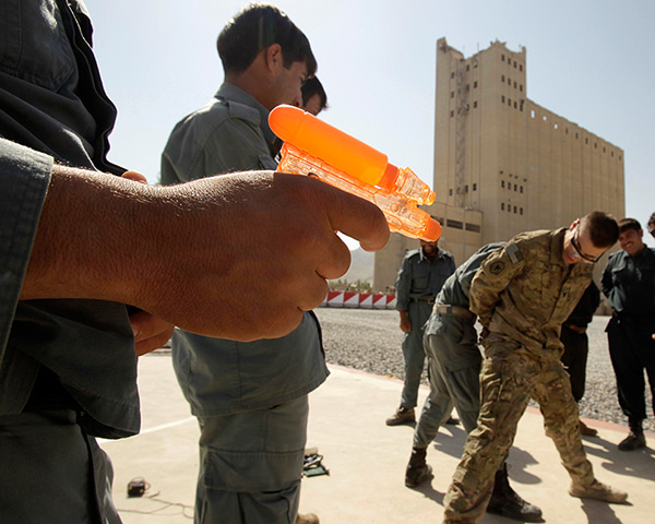 24 hours: Kandahar, Afghanistan: An Afghan policeman holds a toy gun