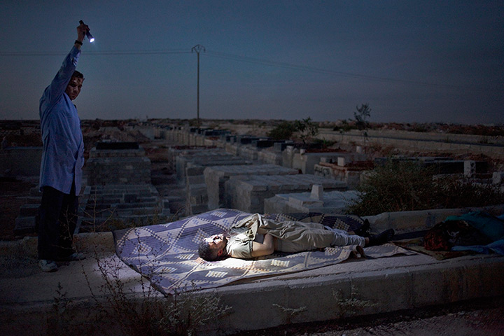 FTA: Maysun: A Free Syrian Army fighter illuminates the body of a man