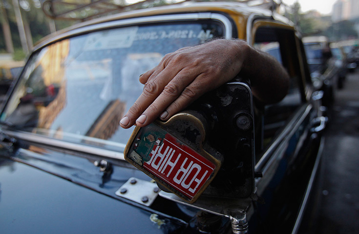 24 hours in pictures: A driver uses a manually operated fare meter on his Premier Padmini taxi