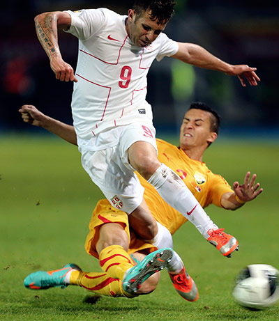 Tuesday WCQ: Serbia's Miralem Suljejmani is tackled by Daniel Georgievski of Macedonia